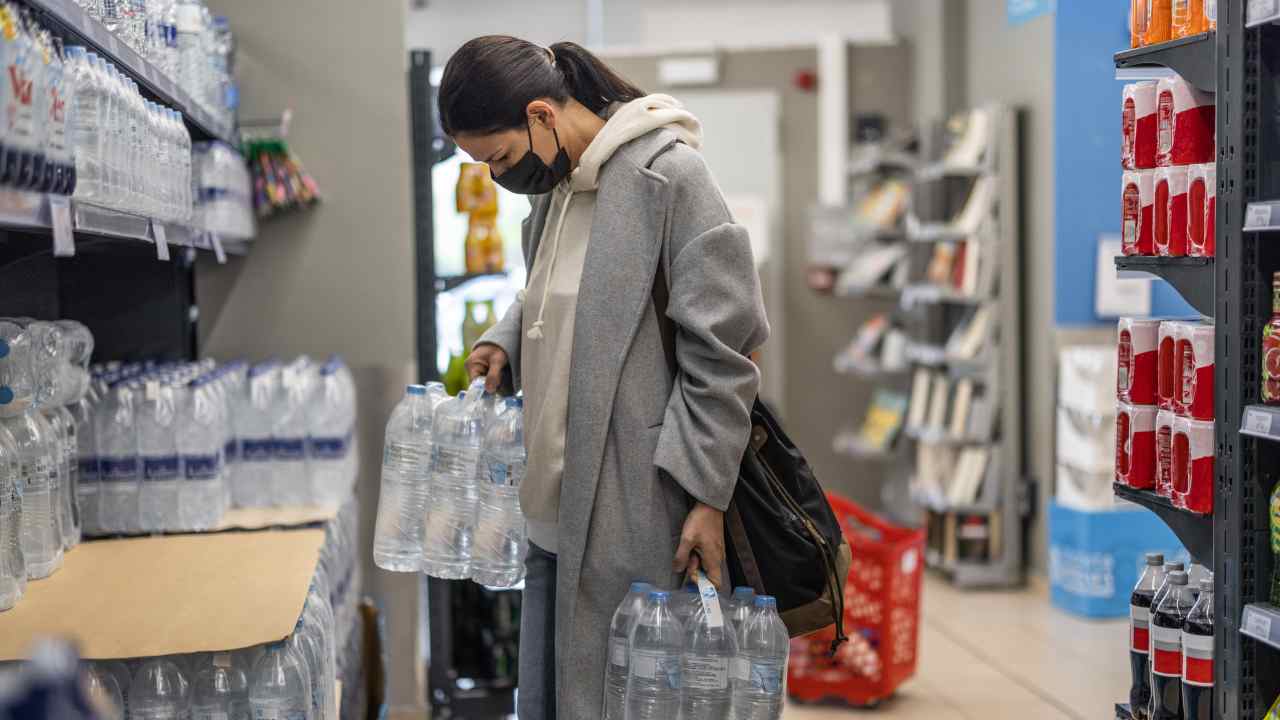 Una donna acquista dell'acqua minerale al supermercato