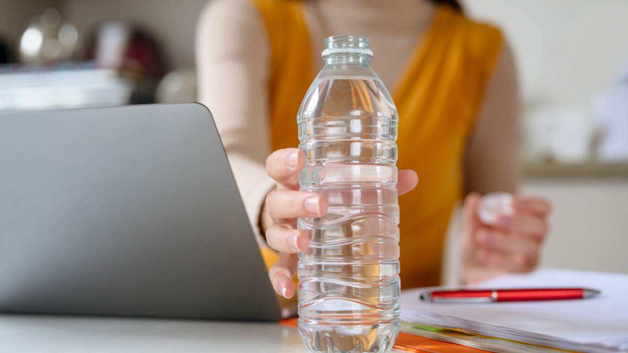 Una donna tiene in mano una bottiglietta d'acqua