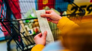 Una donna guarda lo scontrino al supermercato