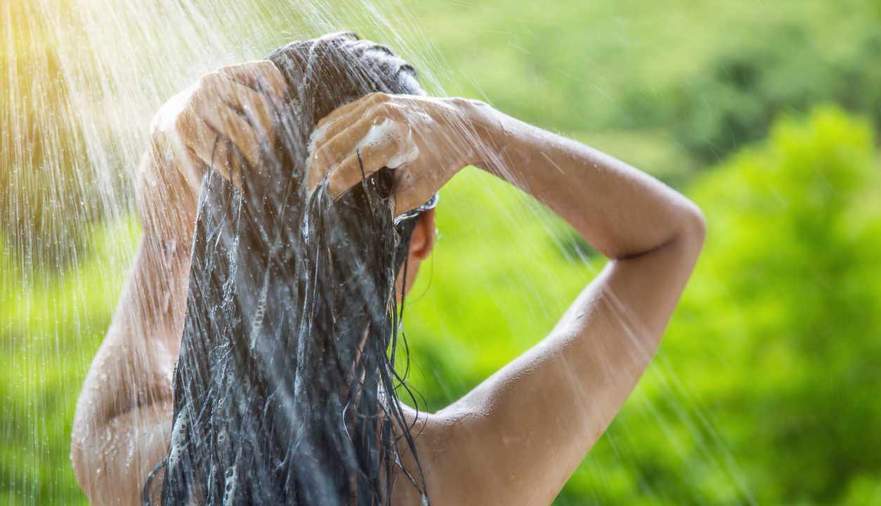 Una donna in una doccia all'aperto
