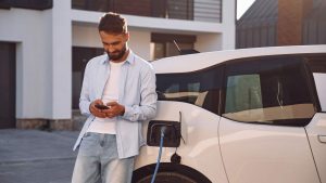 Un uomo mentre ricarica la sua auto elettrica