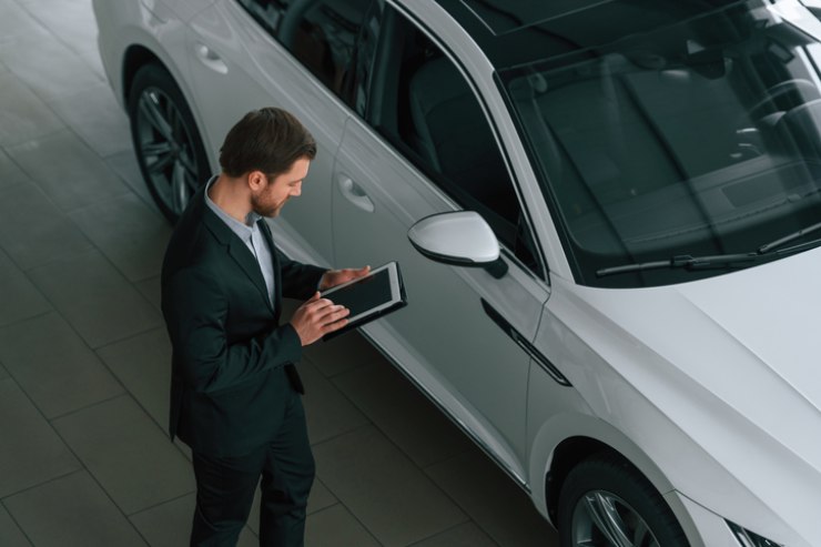 Un uomo consulta un tablet in una concessionaria d'auto