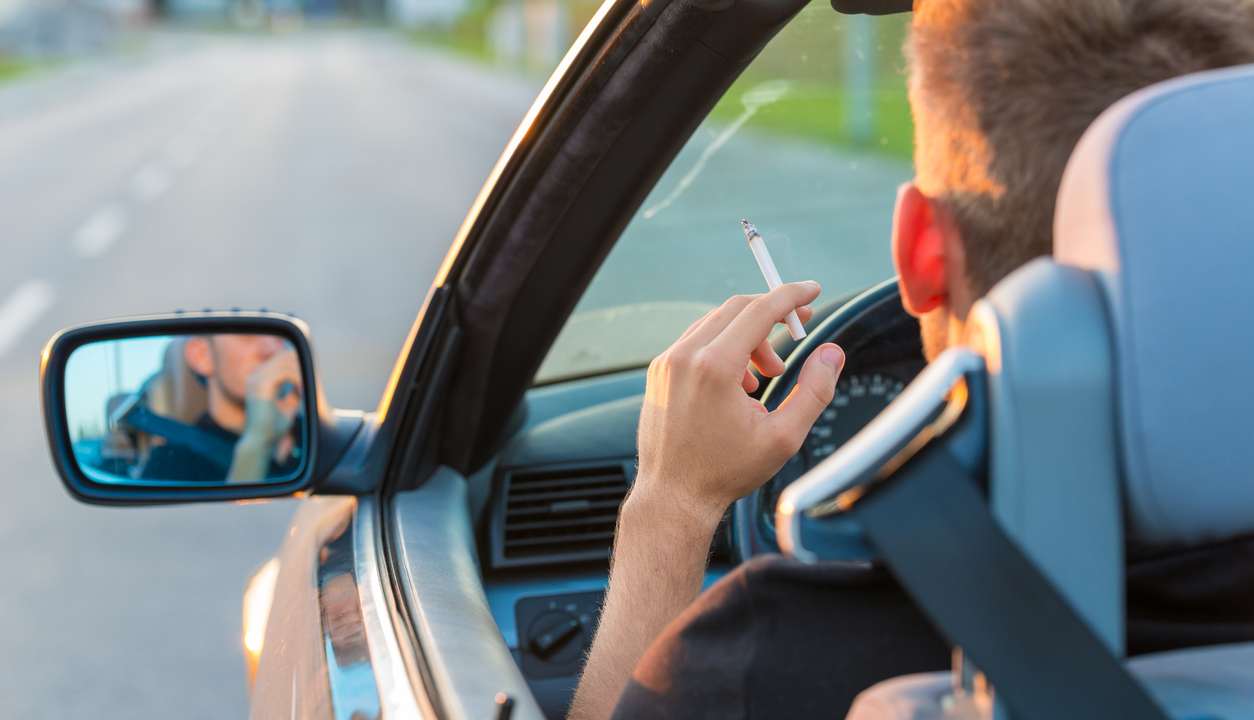 Un uomo al volante con la sigaretta