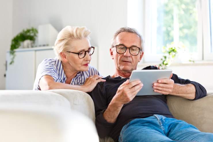 Una coppia di anziani consulta un tablet