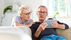 Una coppia di anziani consulta un tablet