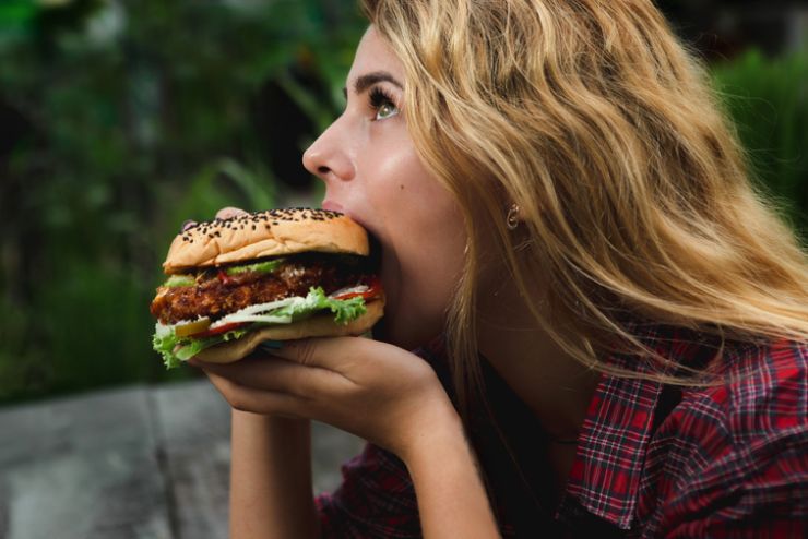 Una donna mangia un hamburger