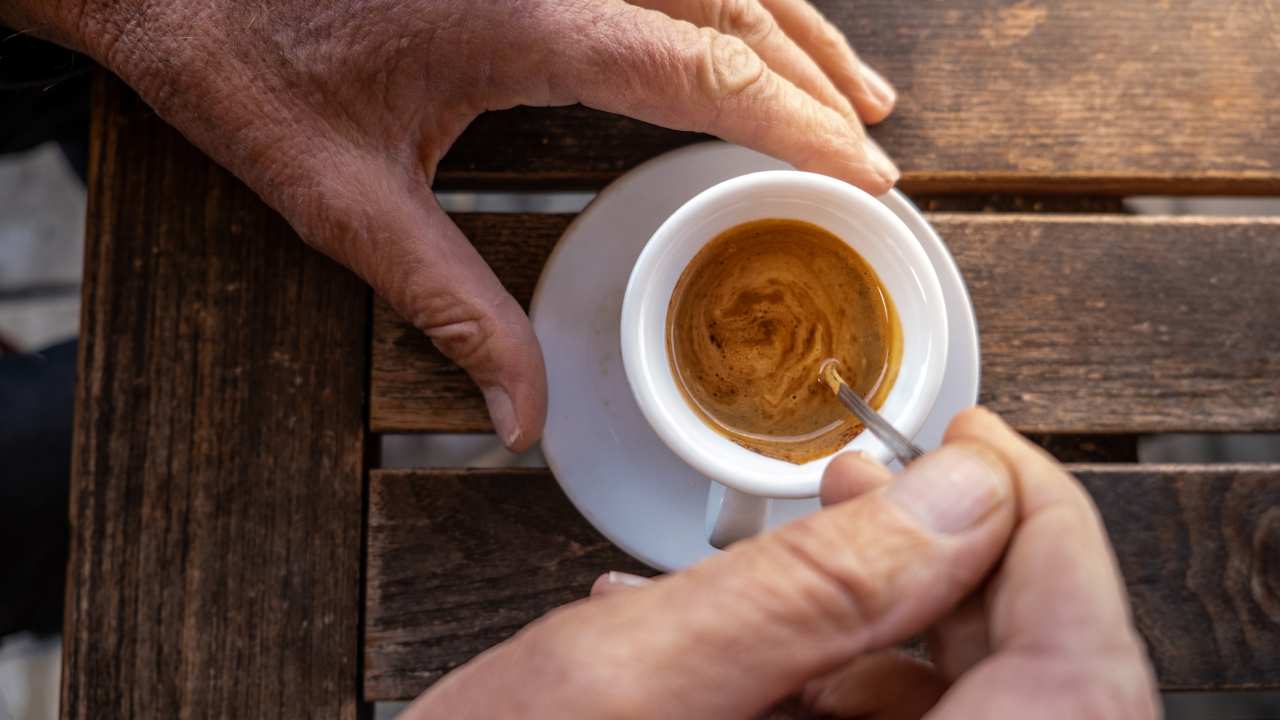 Un uomo mescola una tazza di caffè 