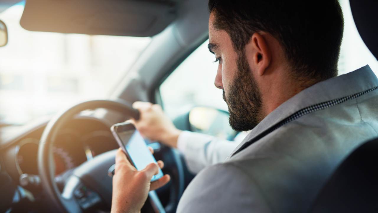 Un uomo utilizza il cellulare mentre guida