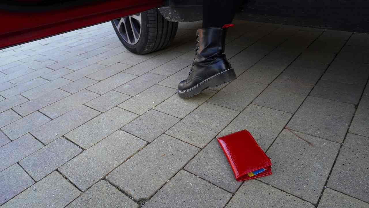 Un portafoglio perso da una persona che sta salendo in macchina