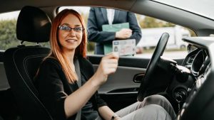 Una donna in auto esibisce la sua patente