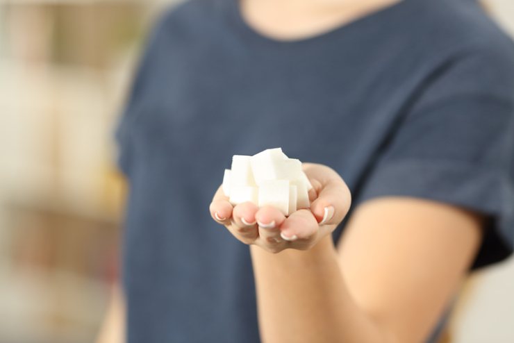 Una donna tiene in mano dei cubetti di zucchero