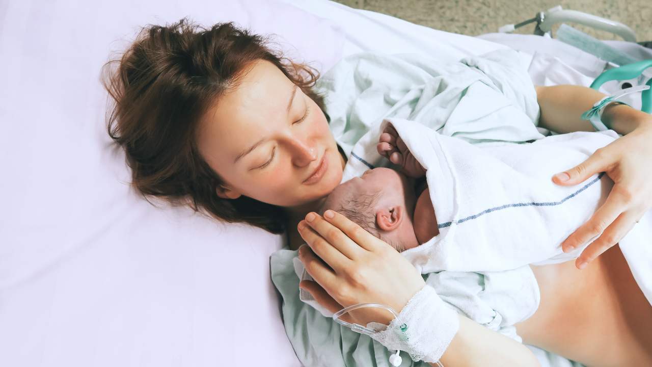 Una madre tiene in braccio il figlio appena nato