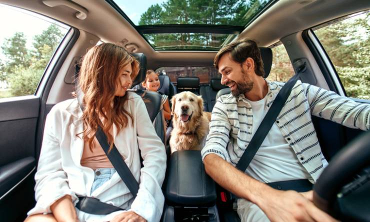 Una famiglia in auto insieme al cane