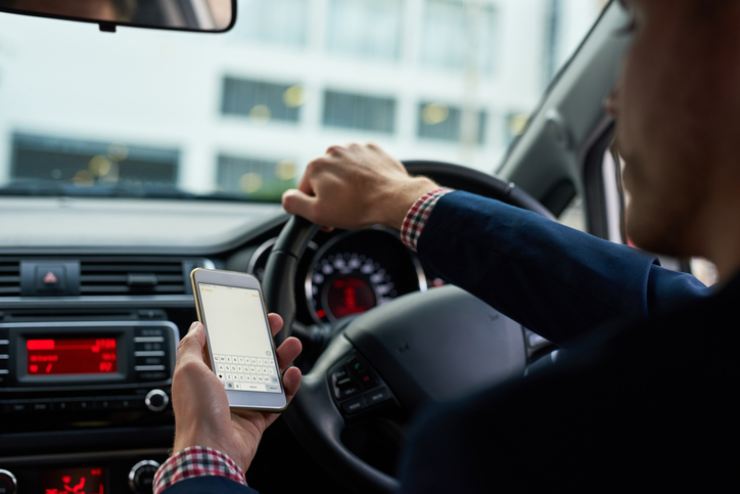 Automobilista consulta il cellulare mentre guida