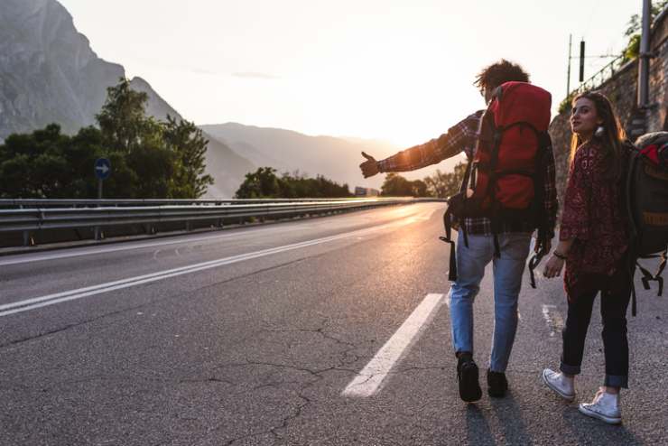 Due ragazzi fanno autostop sul ciglio della strada