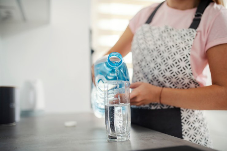 Una donna versa dell'acqua in un bicchiere