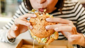 Una donna mangia un hamburger