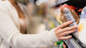 Una donna tra gli scaffali del supermercato